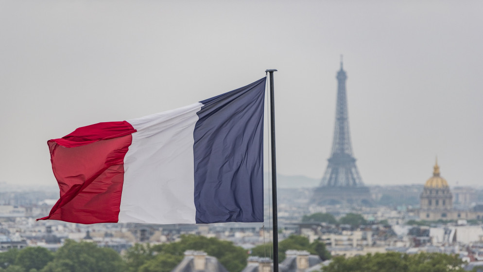 علم فرنسا ومن خلفه برج إيفل المعلم الشهير في العاصمة الفرنسية باريس. (shutterstock)