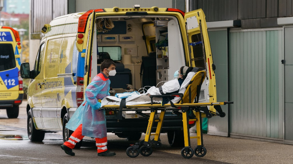 مسعف ينقل امرأة من سيارة إسعاف خارج مستشفى بورغوس شمالي إسبانيا. 21/10/2020. (أ ف ب)