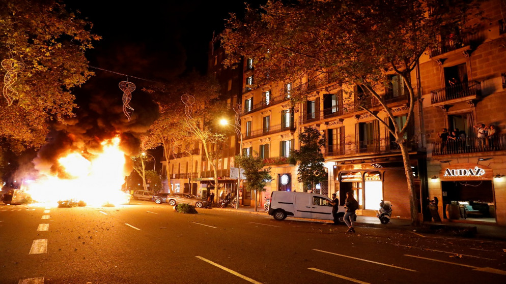 أشخاص ينظرون إلى حاجز مشتعل خلال احتجاج على إغلاق المطاعم والصالات الرياضية، وسط تفشي كورونا، برشلونة ، إسبانيا ، 30 تشرين الأول/ أكتوبر 2020. (رويترز)