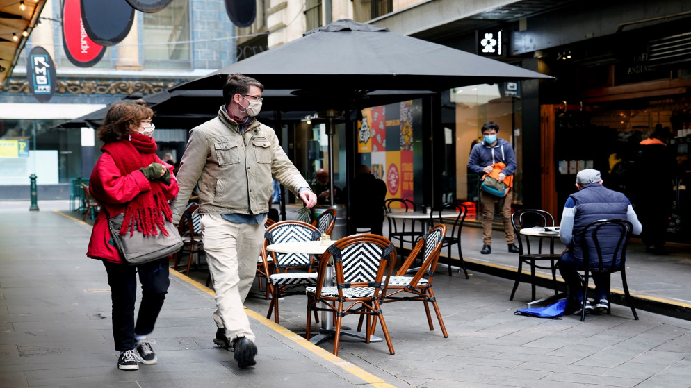أشخاص يسيرون بالقرب من مقهى بعد تخفيف قيود فيروس كورونا المستجد في ولاية فيكتوريا في أستراليا، 28 تشرين الأول/أكتوبر 2020. (رويترز)