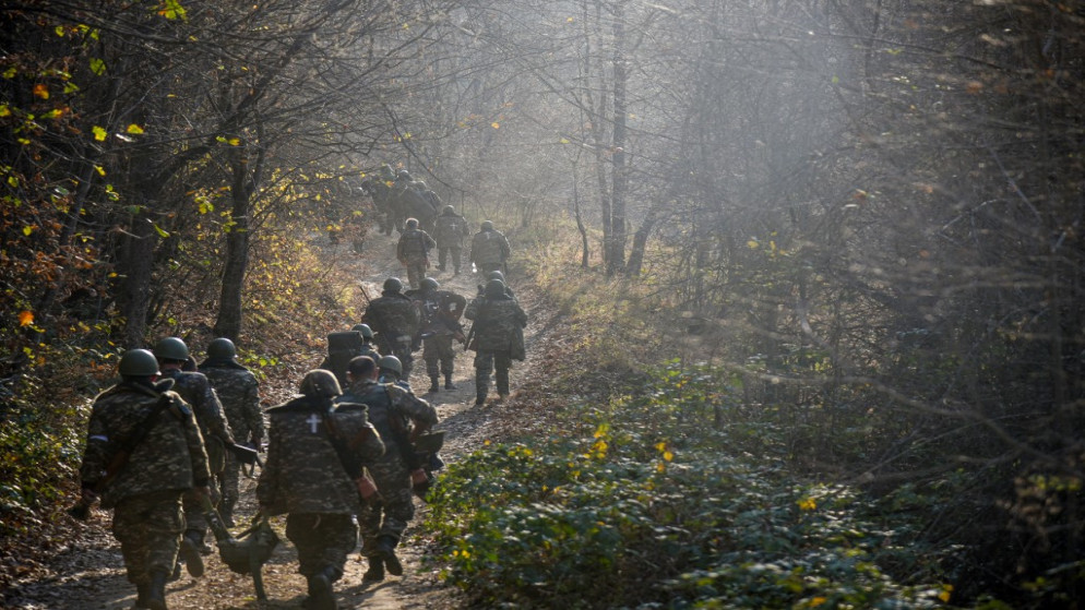 جنود متطوعون يسيرون في طريق في غابة خلال النزاع الأذري الأرميني في نارغورني كارباخ. (أ ف ب)