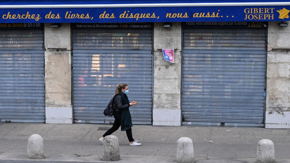 أحد المشاة يسير أمام منشئة مغلقة في اليوم الرابع من الإغلاق لاحتواء انتشار فيروس كورونا في فرنسا، 2 تشرين الثاني/نوفمبر 2020. (أ ف ب)