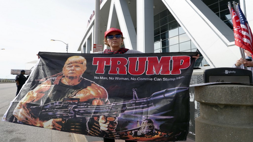 أحد مؤيدي ترامب يحمل علمًا يصور الرئيس على أنه رامبو، أثناء احتجاج خارج ملعب ستيت فارم أرينا، أتلانتا ، جورجيا.، 5 نوفمبر 2020. (أ ف ب)