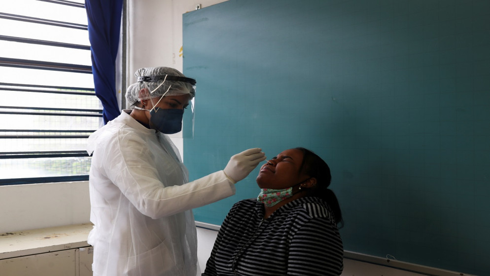 عامل رعاية صحية يجري اختبار PCR لطالب في مدرسة حكومية في البرازيل، 15 تشرين الأول/ أكتوبر 2020. (رويترز)