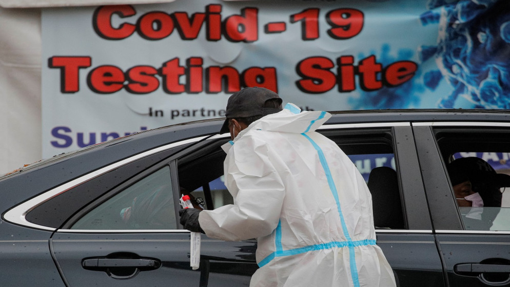 عامل رعاية صحية يأخذ مسحة من شخص يجلس في سيارة في مركز اختبار COVID-19، الولايات المتحدة، 12 تشرين الثاني/ نوفمبر 2020. (رويترز)