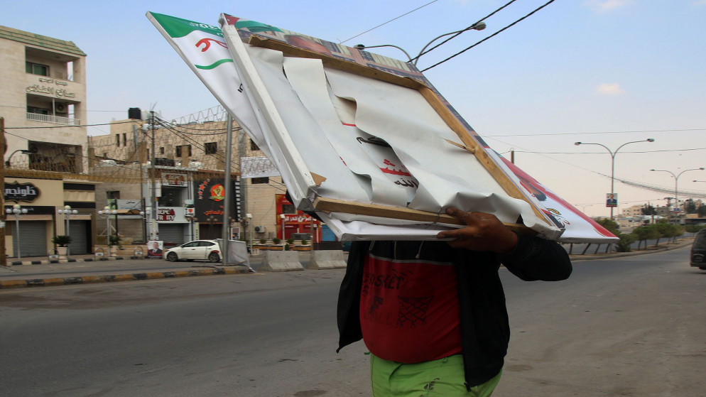 عامل وطن يزيل لوحات دعاية انتخابية من شوارع عمّان. (صلاح ملكاوي/ المملكة)