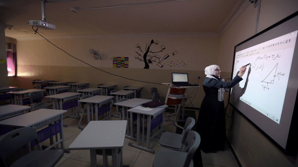 صورة تعبيرية لمعلمة تعطي دروسا لطلابها عن بعد من أحد الغرف الصفية في أحد مدارس عمّان. (رويترز)