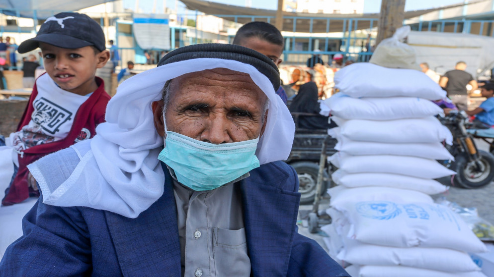 فلسطينيون ينتظرون دورهم لاستلام معونات غذائية من مركز توزيع تابع لوكالة الأمم المتحدة لغوث وتشغيل اللاجئين الفلسطينيين (أونروا) في مخيم خان يونس في قطاع غزة. 15/10/2020. (shutterstock)