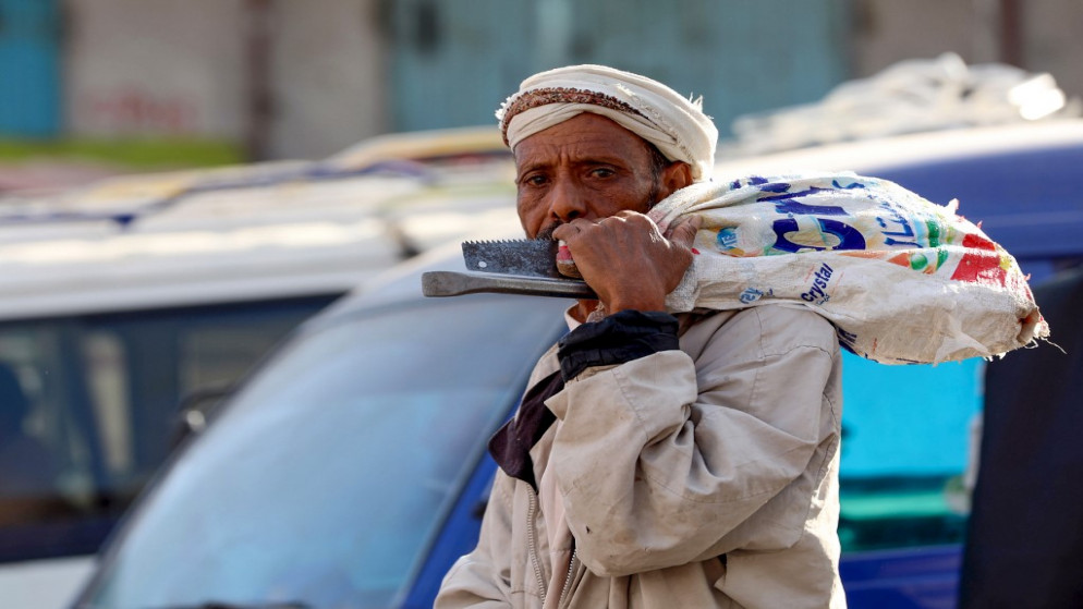 يمني يبحث عن العمل وهو يحمل معداته في مدينة تعز. (أ ف ب)