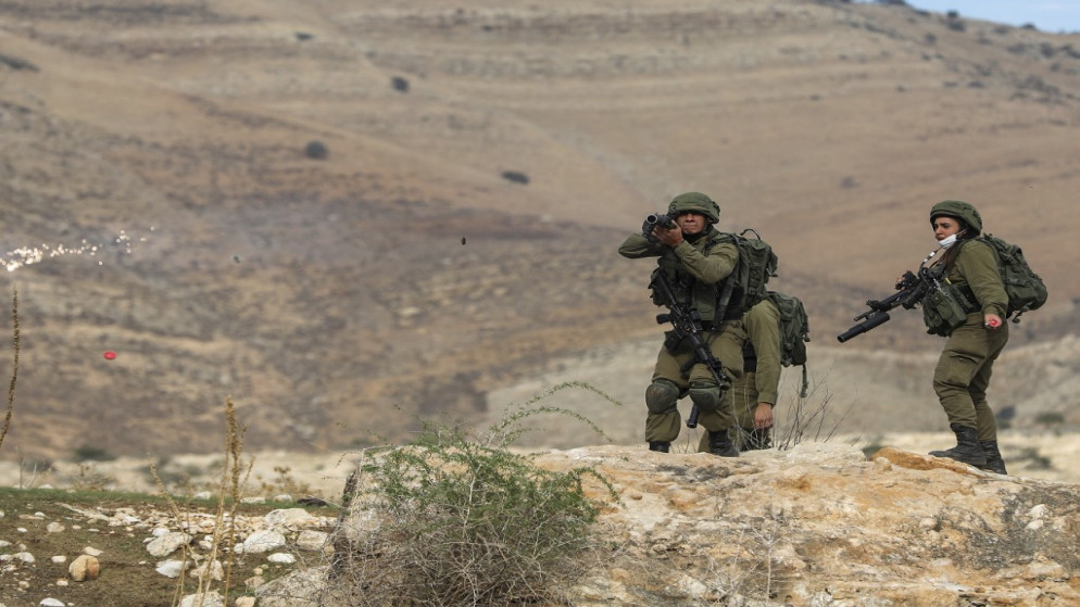 جنود الاحتلال الإسرائيلي وهم يطلقون النار تجاه فلسطينيين. (أ ف ب)