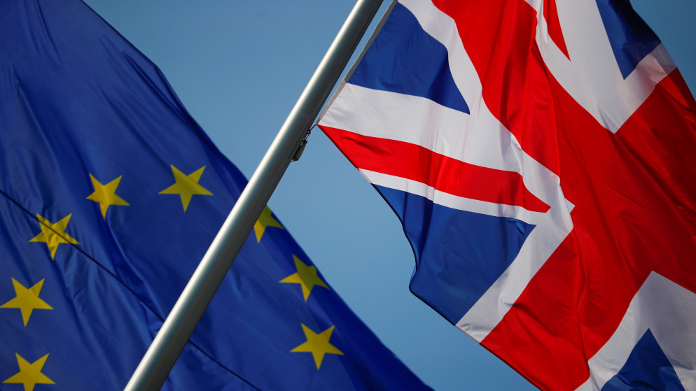 علما بريطانيا والاتحاد الأوروبي أمام مقر المستشارة الألمانية أنغيلا ميركل، 9 نيسان/أبريل 2020. (رويترز)