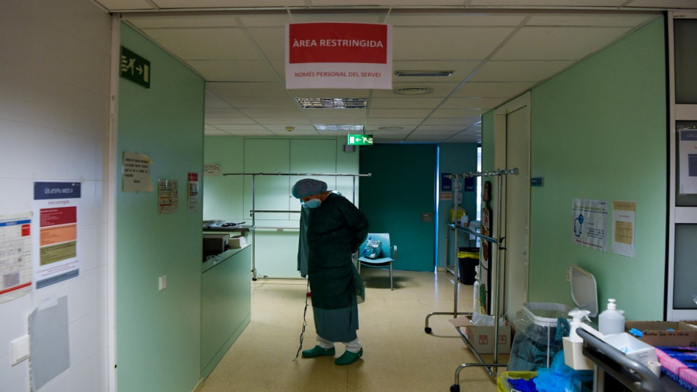 عامل رعاية صحية يرتدي معدات واقية قبل الاعتناء بمرضى فيروس كورونا في وحدة العناية المركزة (ICU) بالمستشفى الجامعي في إغوالادا، 1 كانون الأول/ ديسمبر 2020. (أ ف ب)
