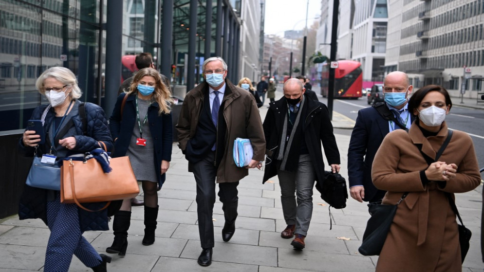 كبير مفاوضي الاتحاد الأوروبي ، ميشيل بارنييه (وسط) يرتدي غطاءً واقيا للوجه لمكافحة انتشار فيروس كورونا ، يعود إلى الفندق مع فريقه حيث تستمر المفاوضات بشأن صفقة تجارية بين الاتحاد الأوروبي والمملكة المتحدة في لندن .28 نوفمبر 2020.(أ ف ب)