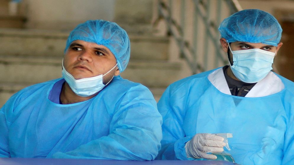 عاملان في القطاع الصحي في قطاع غزة داخل مستشفى لإجراء فحص الكشف عن فيروس كورونا. (رويترز)
