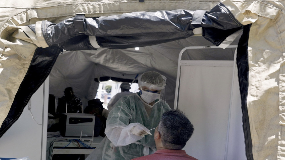 ممرضة تجري اختبار مسحة عينة كوفيد-19 على مريض كجزء من الإجراءات الجديدة التي اتخذتها حكومة ريو دي جانيرو ضد تفشي الفيروس في ساو جونكالو، البرازيل، 04/12/2020. (رويترز)