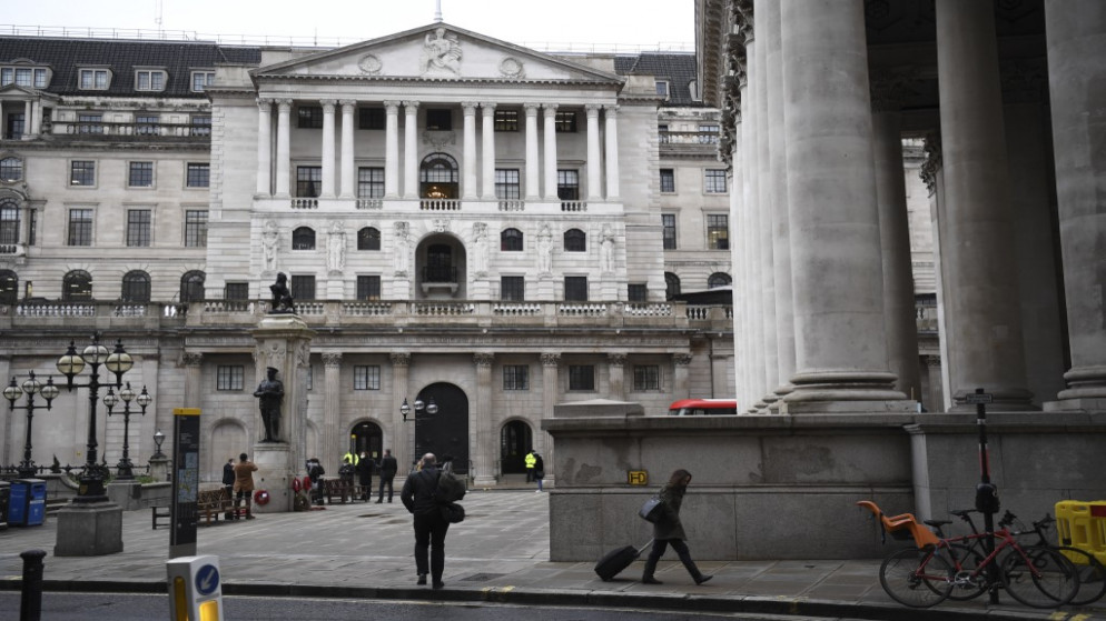 أشخاص يمشون أمام بنك إنجلترا والبورصة الملكية في مدينة لندن، 9 كانون الأول/ديسمبر 2020. (أ ف ب)