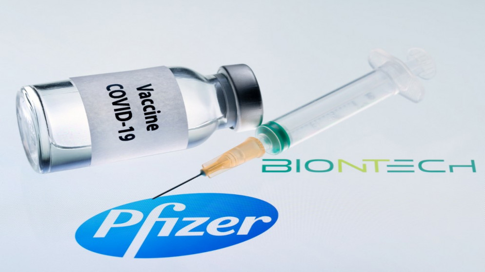 تظهر زجاجة مكتوب عليها "لقاح COVID-19" وحقنة بجوار شعاري Pfizer و BioNtech، في 23 نوفمبر 2020. (أ ف ب)