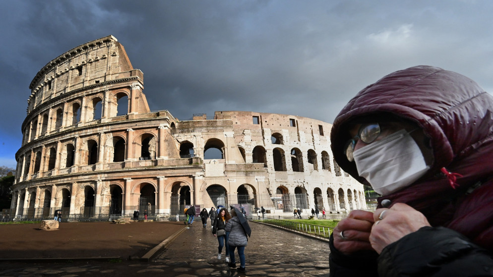 رجل يرتدي كمامة واقية قرب المدرج الروماني الكولوسيوم في العاصمة الإيطالية روما، 7 آذار/مارس 2020. (أ ف ب)