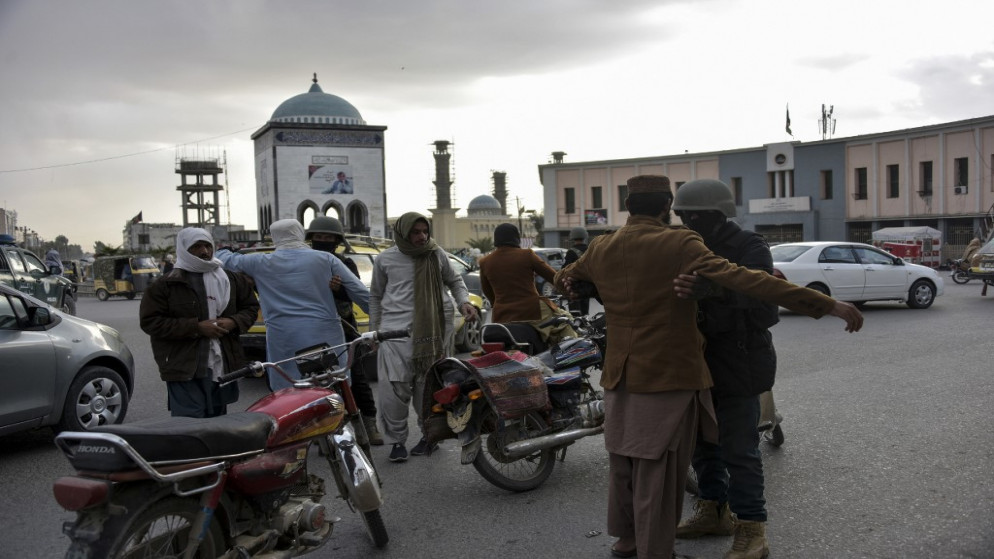 رجال الشرطة الأفغانية يفتشون الناس عند نقطة تفتيش في تشوك شاهيدان في قندهار ، 13 ديسمبر ، 2020.(أ ف ب)
