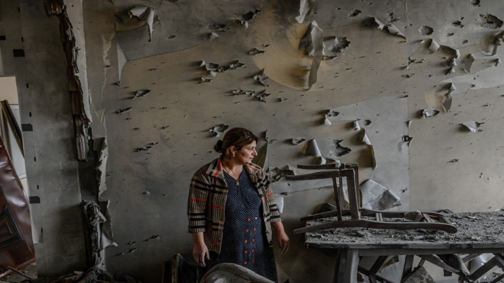 سيدة تقف داخل شقتها المدمرة بعد وقف إطلاق النار أثناء النزاع العسكري بين أرمينيا وأذربيجان حول منطقة ناغورنو كاراباخ الانفصالية ، في بلدة تيرتر ، أذربيجان ،.10 أكتوبر 2020. (أ ف ب)