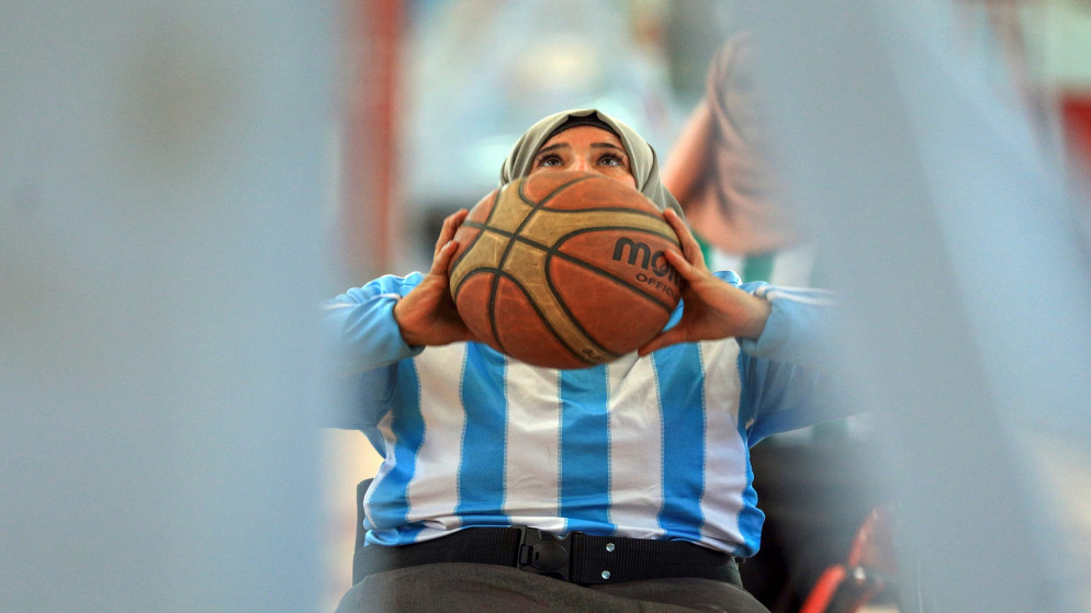 امرأة يمنية من ذوات الاحتياجات الخاصة تستعد لتسديد كرة السلة خلال بطولة محلية على كراسٍ متحركة في العاصمة اليمنية صنعاء. 08/12/2020. (محمد حويس / أ ف ب)