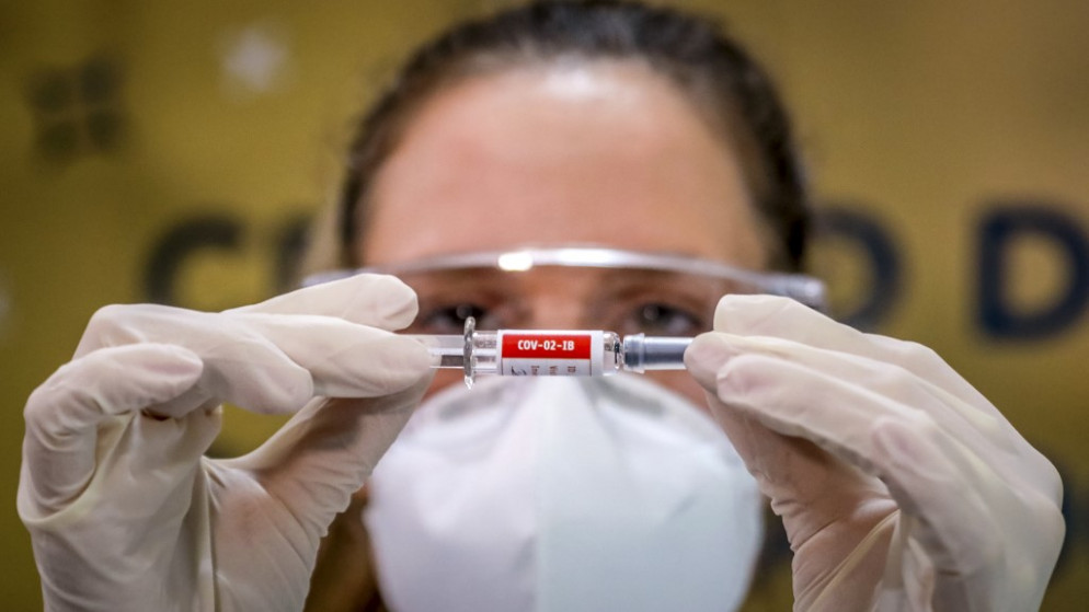 ممرضة تحمل عينة من اللقاح الصيني ضد كوفيد-19 في البرازيل. (أ ف ب)