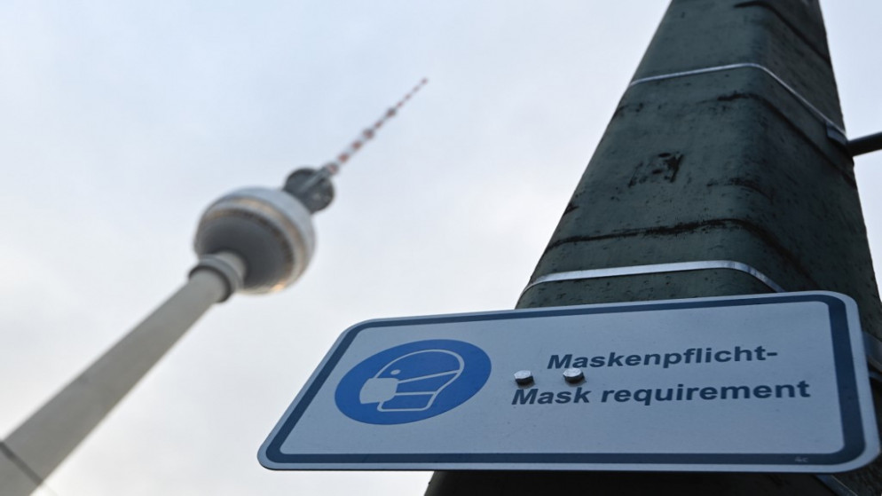 لافتة تشير أن أقنعة الوجه مطلوبة بجوار برج التلفزيون التاريخي في برلين، 16 كانون الأول/ديسمبر 2020 (أ ف ب)
