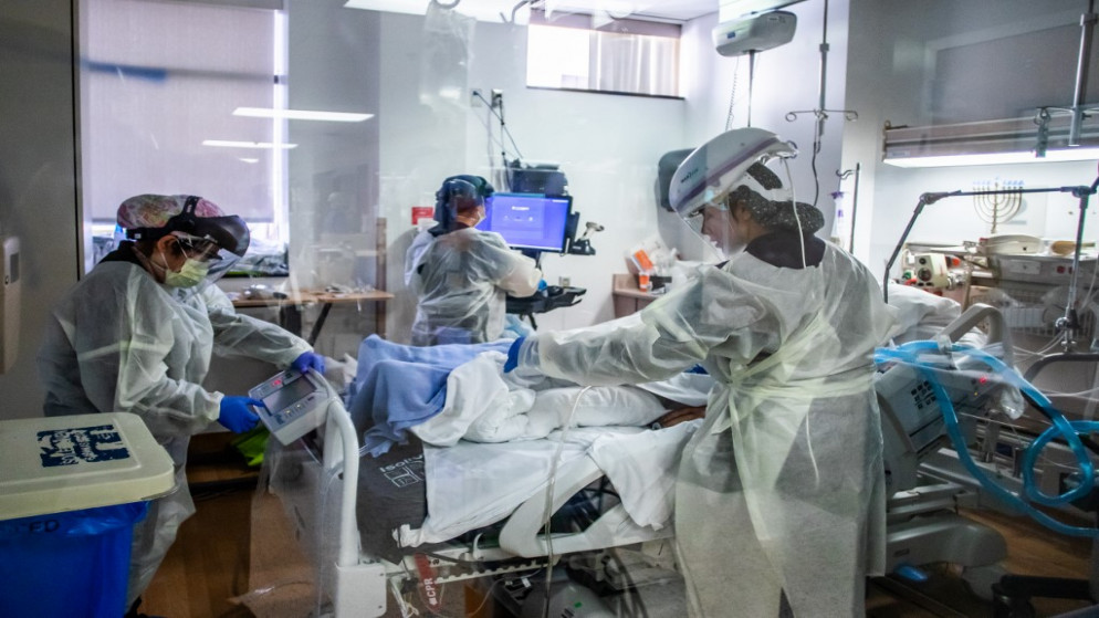 ممرضات يرتدون معدات وقاية شخصية (PPE) يحضرون إلى مريض Covid-19 في وحدة العناية المركزة (ICU) في مركز بروفيدنس سيدارز-سيناء ترزانا الطبي في ترزانا، كاليفورنيا، 18 ديسمبر 2020. (أ ف ب)