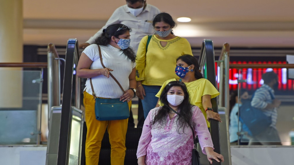 أشخاص يرتدون كمامات للوجه كإجراء وقائي ضد فيروس كورونا Covid-19، شوهدوا داخل مركز تسوق في ثين في ضواحي مومباي، 18 ديسمبر 2020. (أ ف ب)