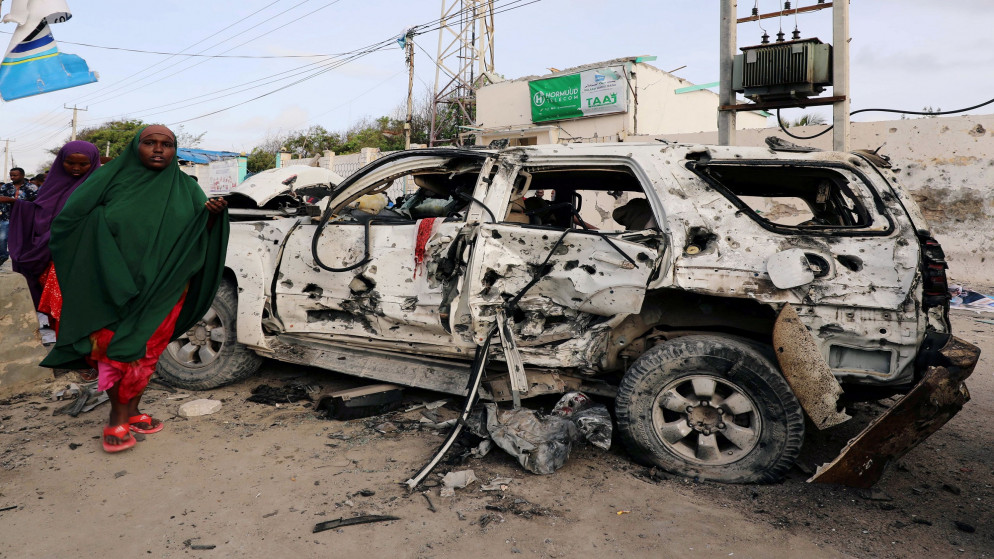 مرور امرأة بجانب سيارة مدمرة بعد تفجير في الصومال. صورة أرشيفية. (رويترز)