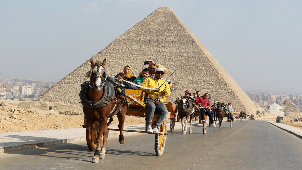 زوار يركبون عربة أمام هرم الجيزة الأكبر، مصر، 18 ديسمبر 2020. (رويترز)