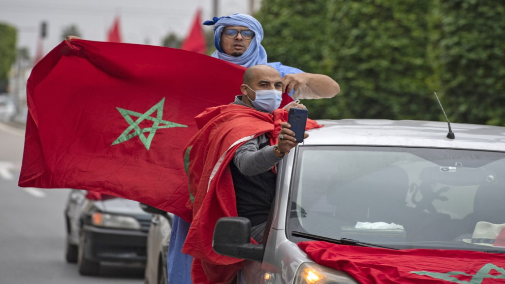 حتفل المغاربة أمام مبنى البرلمان في الرباط بعد أن تبنت الولايات المتحدة خريطة رسمية جديدة للمغرب تتضمن إقليم الصحراء الغربية المتنازع عليه. 13 ديسمبر 2020 . (أ ف ب)