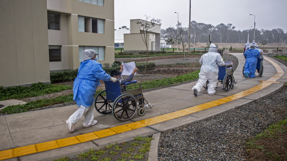 يتم دفع المرضى الذين تعافوا من COVID-19 على كراسي متحركة من قبل العاملين الصحيين بعد خروجهم من فيلا باناميريكانا، مجمع سكني تم تحويله إلى مستشفى، في منطقة فيلا السلفادور، 28 أغسطس 2020. (أ ف ب)