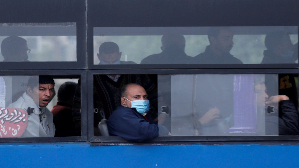 شخص يرتدي الكمامة في حافلة نقل عام في مصر. (رويترز)