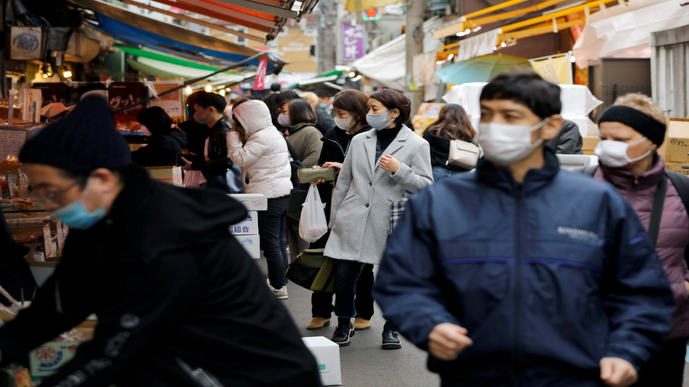 متسوقون يرتدون كمامات واقية يسيرون في سوق تسوكيجي الخارجي، وسط تفشي الفيروس في طوكيو، اليابان ، 24 كانون الأول/ ديسمبر 2020. (رويترز)