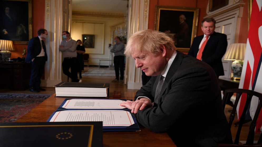 رئيس الوزراء البريطاني بوريس جونسون يوقع اتفاقية التجارة مع الاتحاد الأوروبي في رقم 10 داونينج ستريت في لندن، بريطانيا، 30 كانون الأول/ديسمبر 2020. (رويترز)