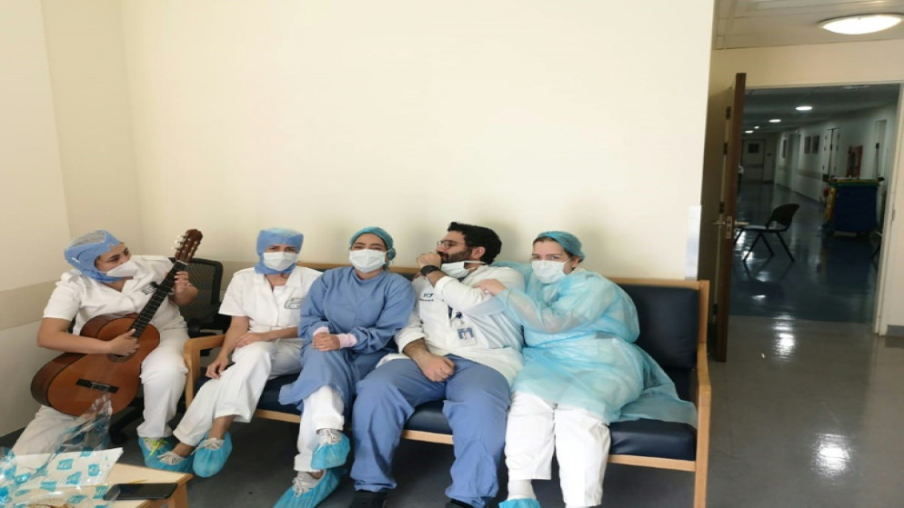 صورة التقطتها ممرضة لزملائها فيما تقوم ممرضة بالعزف على الغيتار، في مستشفى اوتيل ديو في بيروت، 8 ايار/مايو. (أ ف ب)