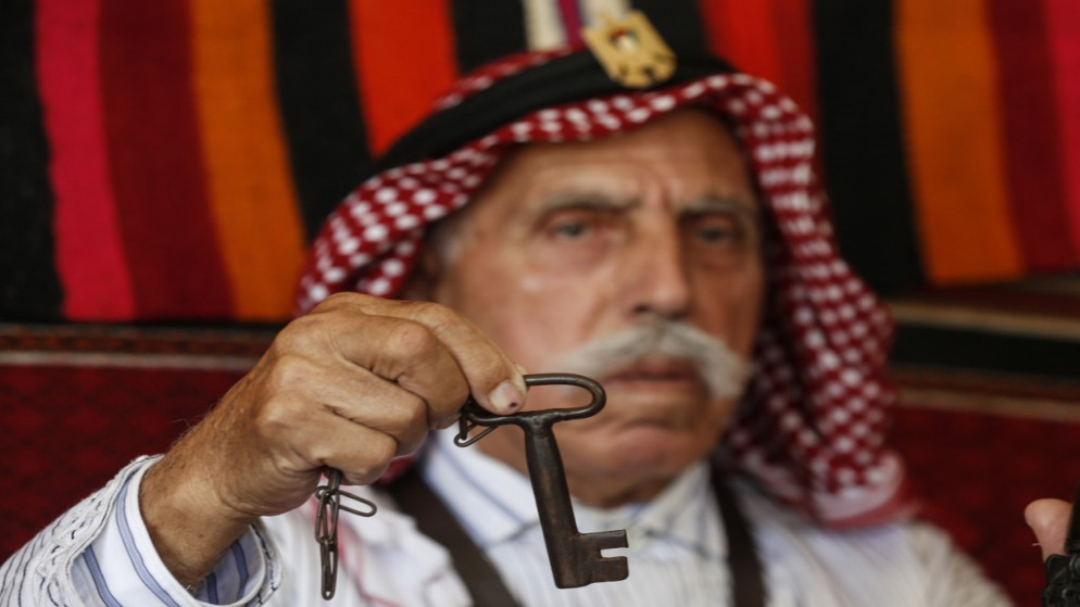 لاجئ فلسطيني 82 عاماً يحمل مفتاح منزله في الذكرى 72 لـ "النكبة"  أثناء وجوده في المنزل؛ بسبب جائحة فيروس كورونا في 14 مايو 2020 .(أ ف ب))