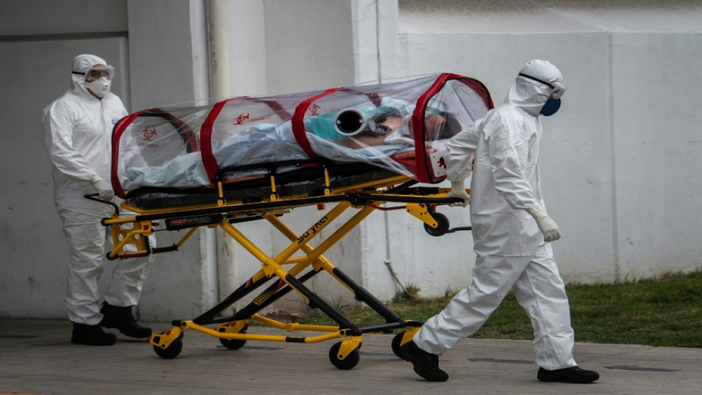 طاقم طبي، ينقل مريضا يشتبه في إصابته بالفيروس إلى مستشفى في العاصمة المكسيكية، 20 أيار/مايو 2020. (أ ف ب)