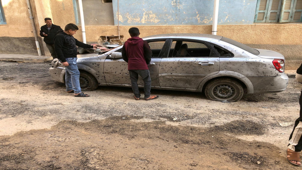 أطفال ليبيون يتفقدون سيارة دمرت بعد قصف. (رويترز)