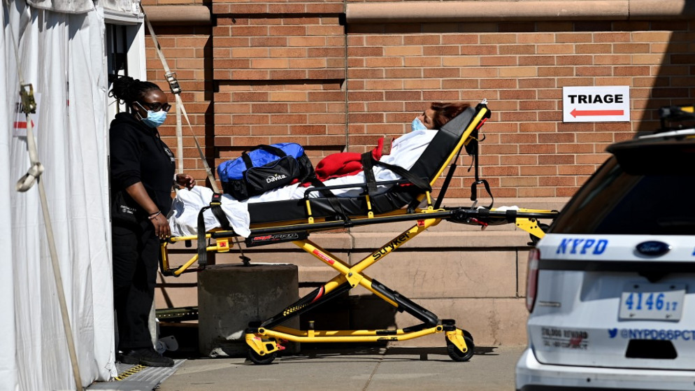 ينقل العاملون الطبيون مريضًا، في حي بروكلين، مدينة نيويورك، 14 مايو 2020. (أ ف ب)