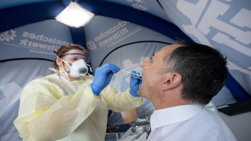موظف في معهد روبرت كوخ للصحة العامة، يأخذ عينة لاختبار فيروس التاجي، جنوب ألمانيا،19 مايو 2020. (أ ف ب)