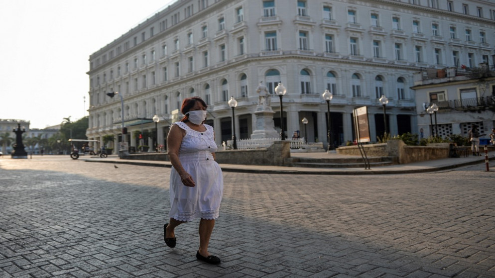 امرأة ترتدي قناع وجه تمشي في شارع في هافانا. 19 مايو 2020  (أ ف ب)