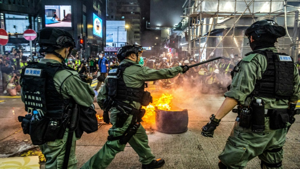 عناصر الشرطة يحاولون منع متظاهرين من قطع طريق في حي مونغ كوك في هونغ كونغ، 27 أيار/مايو 2020. (أ ف ب)