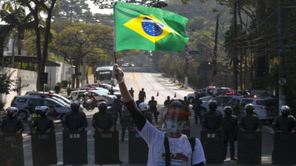 أحد سكان بارايسوبوليس، يشارك في احتجاج للمطالبة بمزيد من المساعدة خلال الجائحة، في ساو باولو، البرازيل، 18 مايو 2020. (أ ف ب)