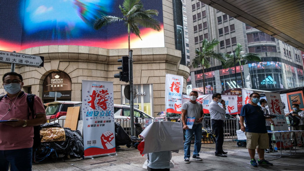 يقف الناس في كشك حيث يمكن للمارة تقديم توقيعاتهم لدعم قانون أمني جديد في هونغ كونغ .29 مايو 2020. (أنتوني والاس / أ ف ب)