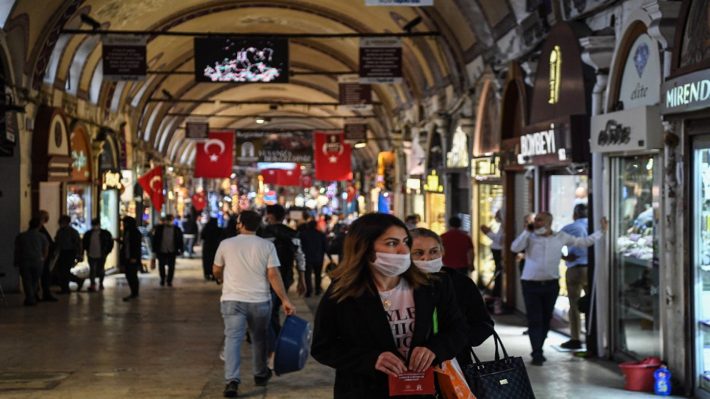 أشخاص يرتدون كمامات واقية للحد من انتشار فيروس كورونا في سوق تجاري في إسطنبول بعد إعادة فتح المطاعم والمقاهي. 01/06/2020. (أوزان كوس / أ ف ب)