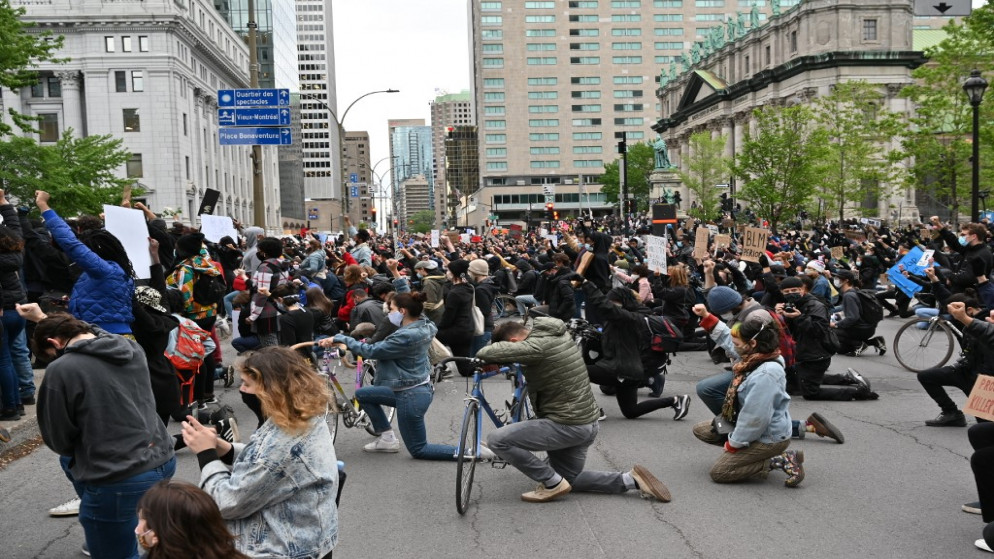 دقيقة صمت في وضعية ركوع على الركبة حدادا على مقتل جورج فلويد، خلال تظاهرة في مونتريال في كندا، 31 أيار/مايو 2020. (أ ف ب)