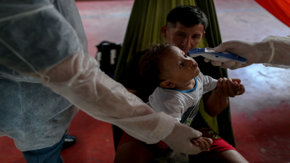 طفل يعاني من أعراض الفيروس، تم فحص درجة حرارته من قبل أطباء بلا حدود، البرازيل، 3 يونيو 2020. (أ ف ب)