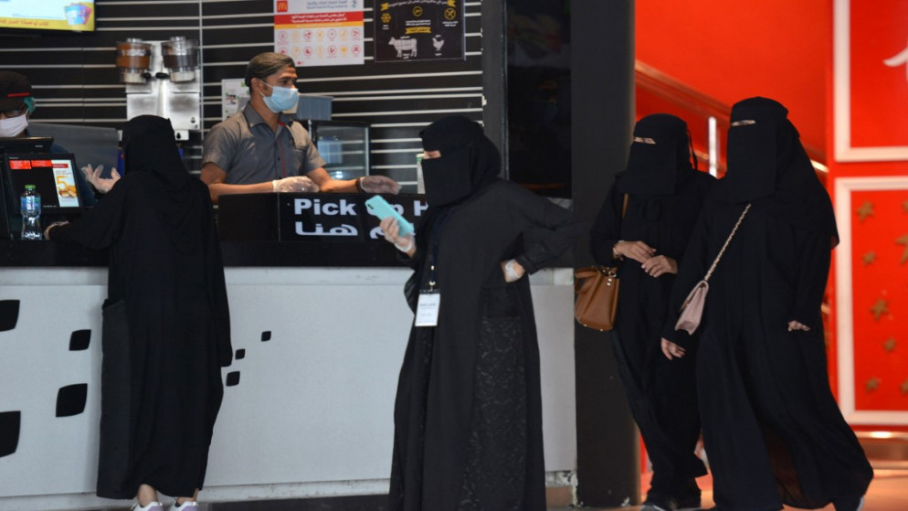 نساء ينتظرن استلام طلباتهن من مطعم في مركز تجاري في العاصمة السعودية الرياض بعد إعادة فتحه بعد تخفيف قيود فرضت لوقف انتشار فيروس كورونا . (فايز نور الدين / أ ف ب)
